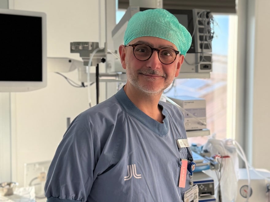 En man i operationskläder står i ett sjukhusrum.